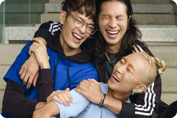 Three people laughing and hugging each other